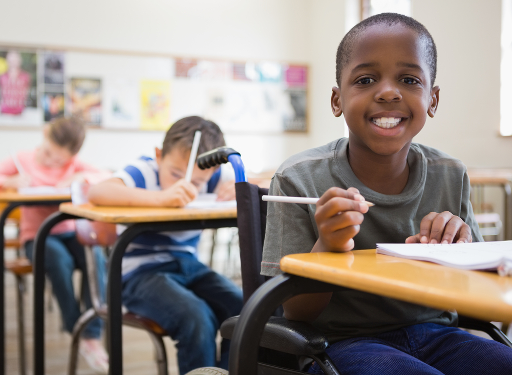 An elementary school student smiling in a classroom